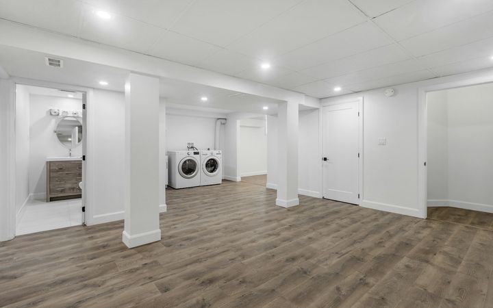 Newly finished basement with a boxed-in post and soffits over the laundry