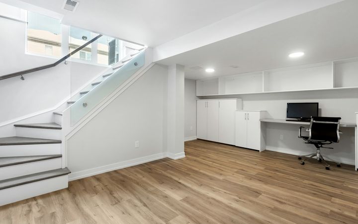 Open stair coming down into a finished basement with white walls