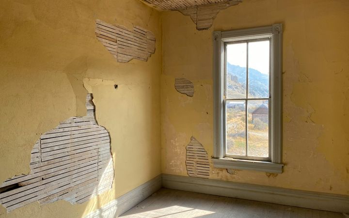 Empty old room with plaster broken away to the wood lath