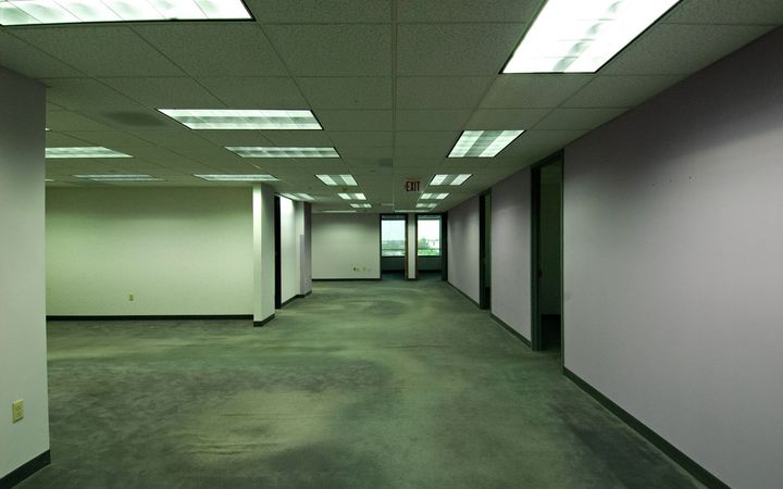 Empty office suite with drywall walls and a grid ceiling, ready for a tenant