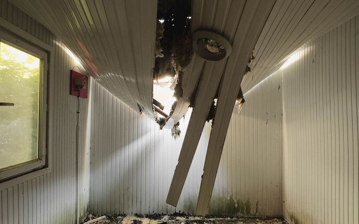 Ceiling boards hanging down into an empty room