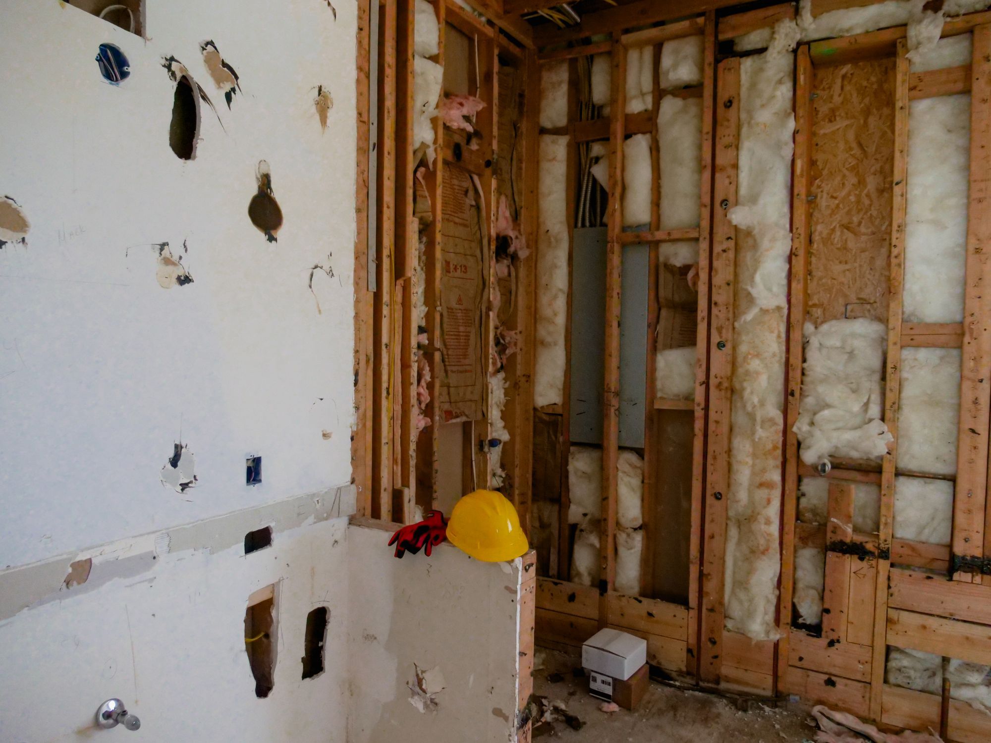 Wall opened down to studs and insulation during a water damage tear-out